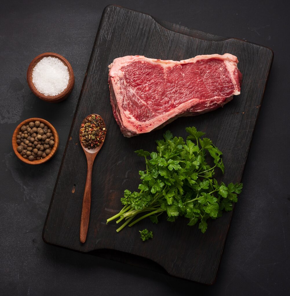 Fresh raw piece of beef meat, striploin steak on a black background